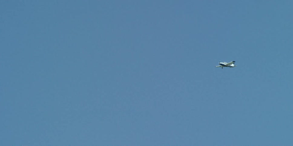 A small airplane flies in the air on a clear day