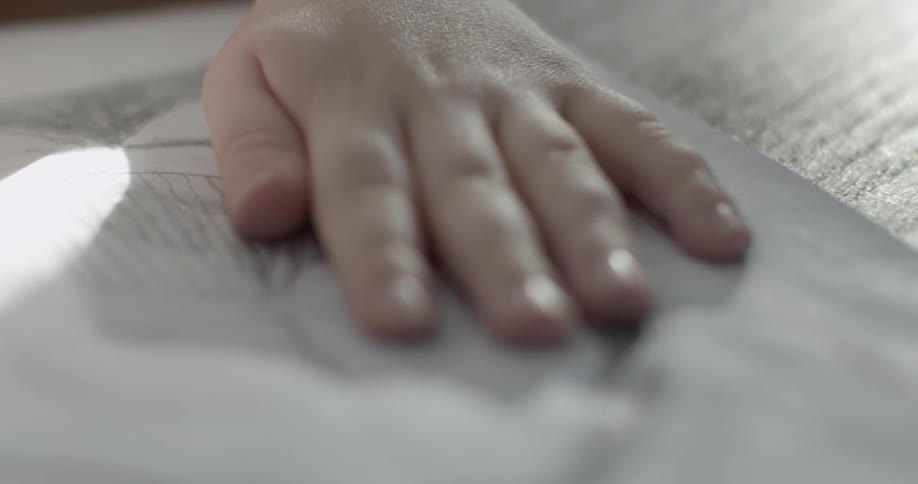 A hand is laying on a paper