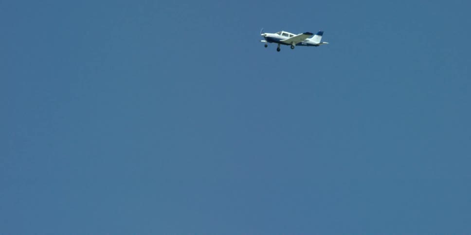 A small airplane flies in the air on a clear day