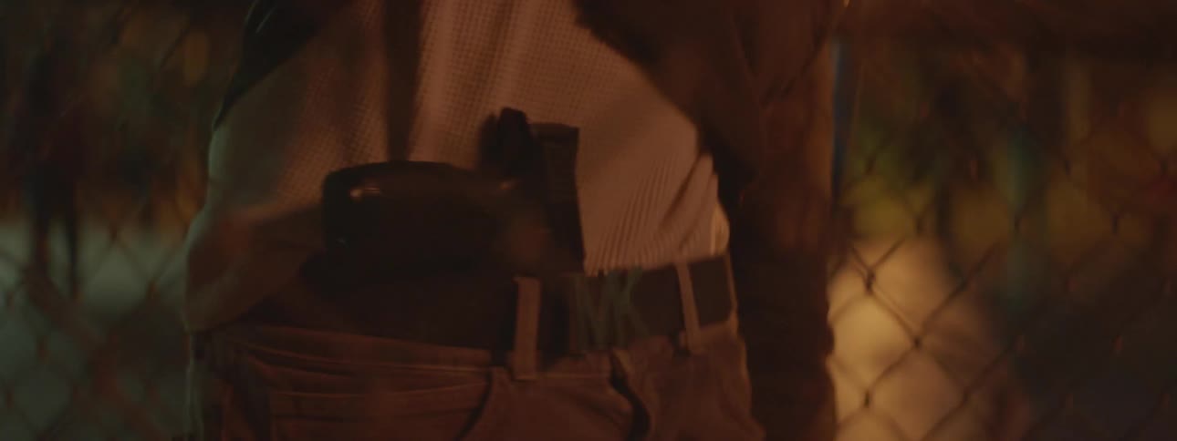 Man pulls up his shirt to reveal gun resting under his belt