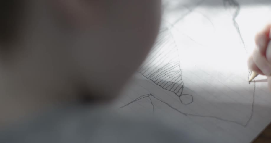 A child is drawing and shading in a picture
