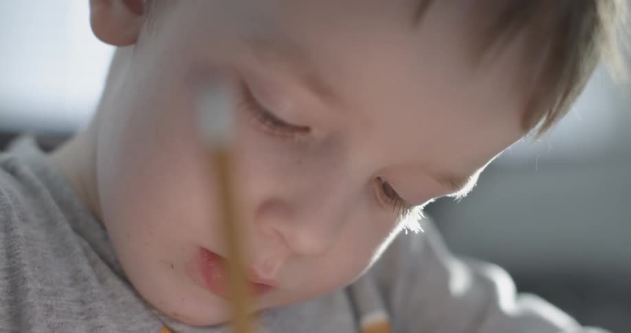A boy is writing with a pencil