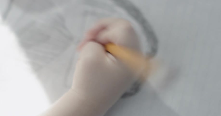 Young person drawing a picture with a pencil