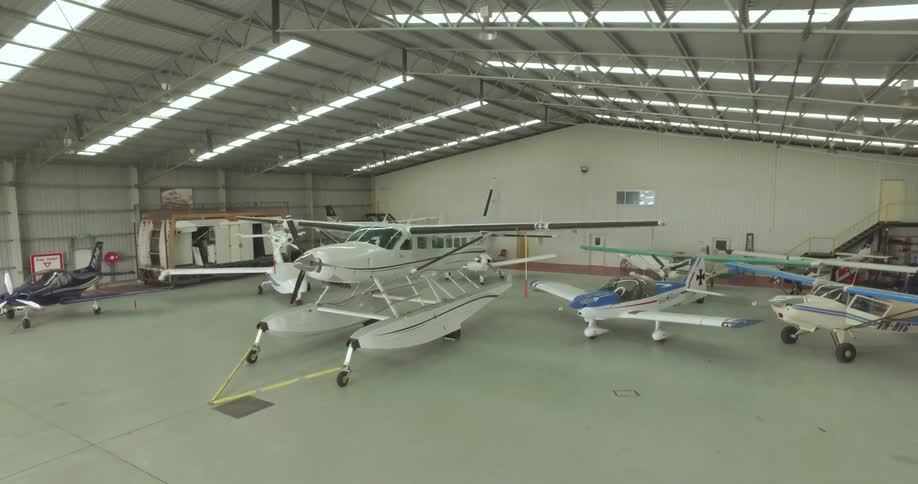 A hangar has many airplanes