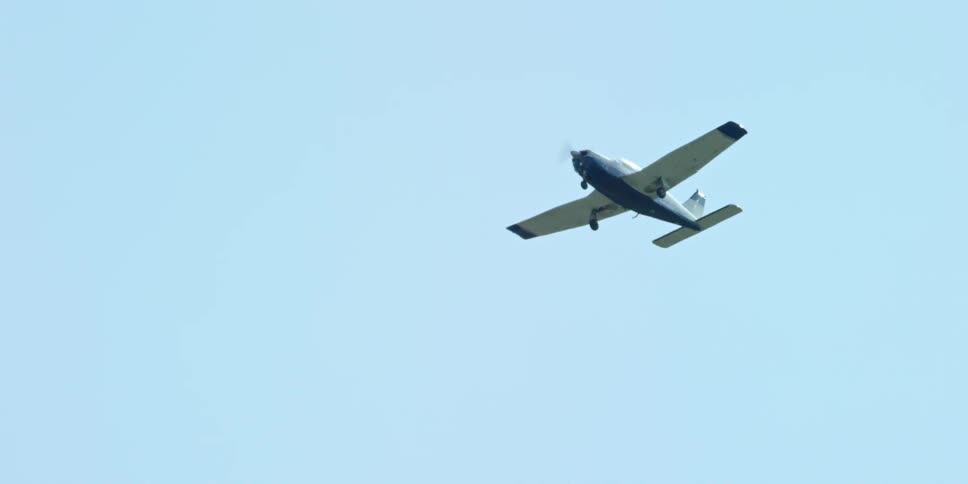 A small plane is flying in a clear blue sky