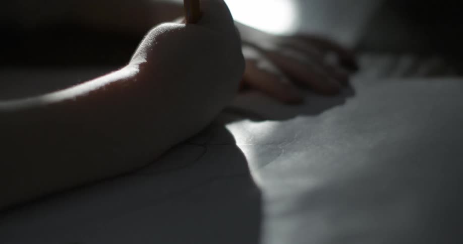 A child colors with a pencil