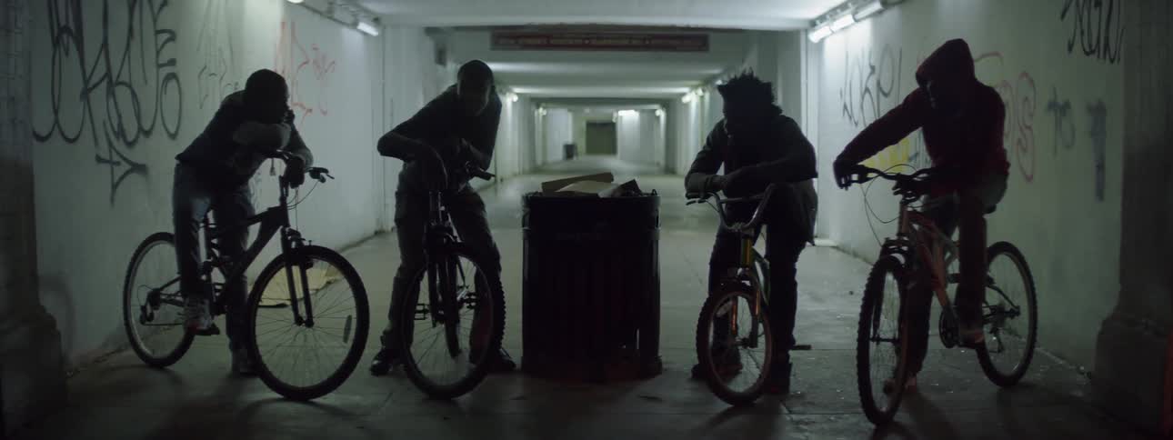 Group of people on bikes in a dark alley