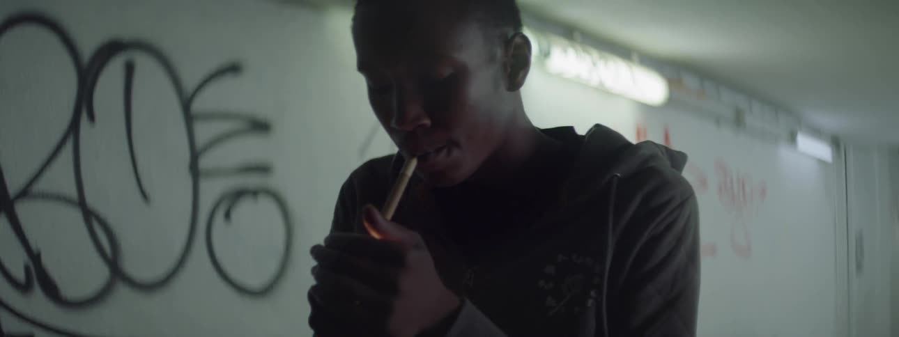 A man lights up a cigarette in a tunnel