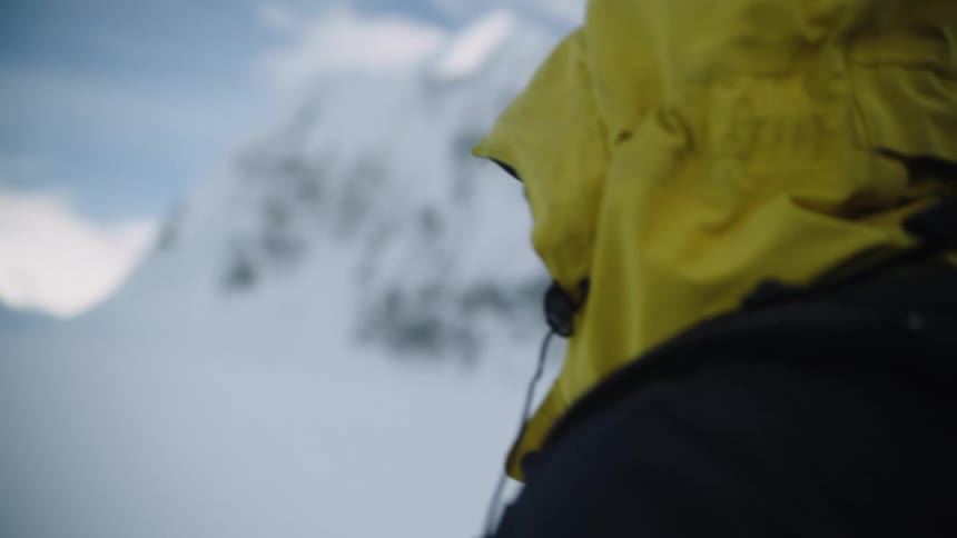 A backpacker hikes through heavy snow on a mountain