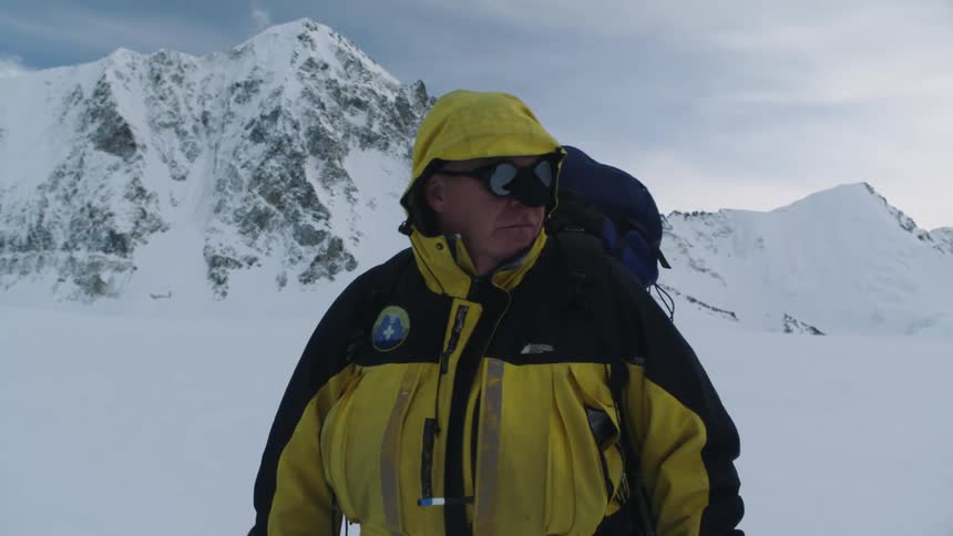 A man is hiking through an arctic area