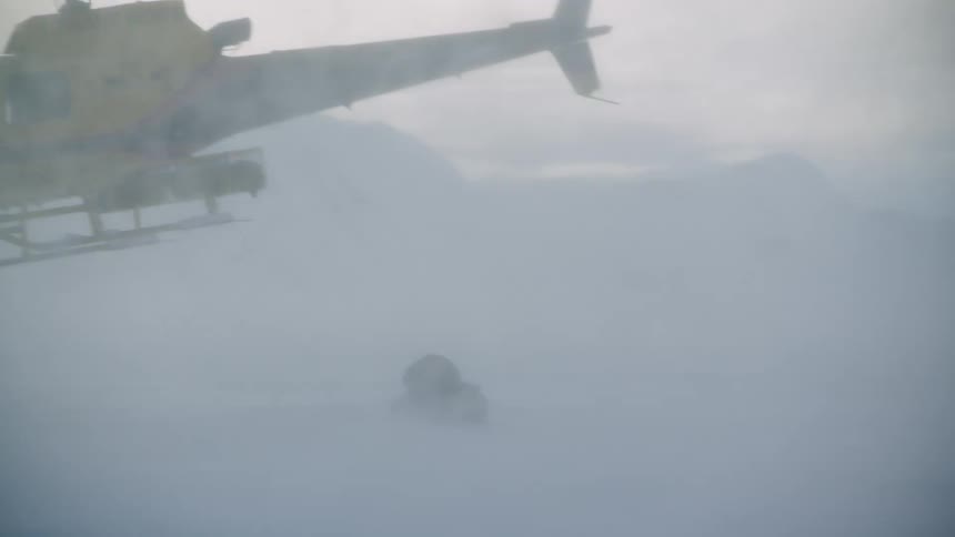 The helicopter takes off in the snow