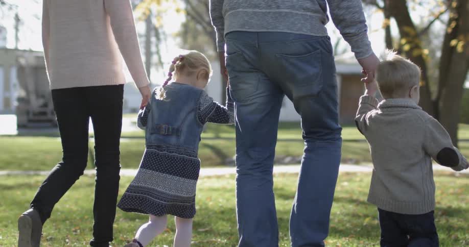 A family walks through the park on a sunny day