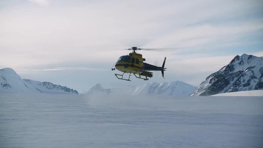 A helicopter is landing in a mountainous landscape