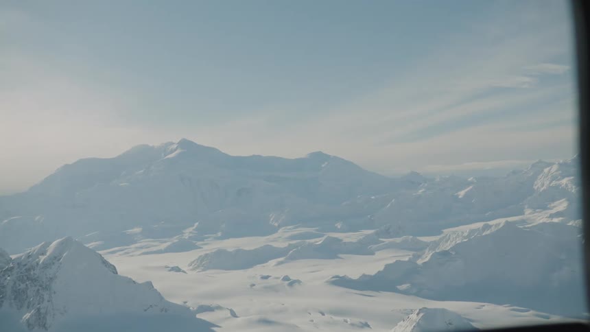 View of snow covered mountains from a helicopter window