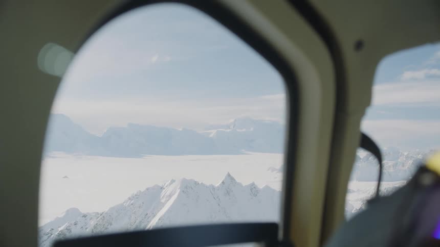 View of snow covered mountains from a helicopter window