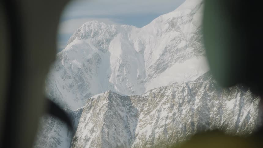 A person is standing near a mountain in winter