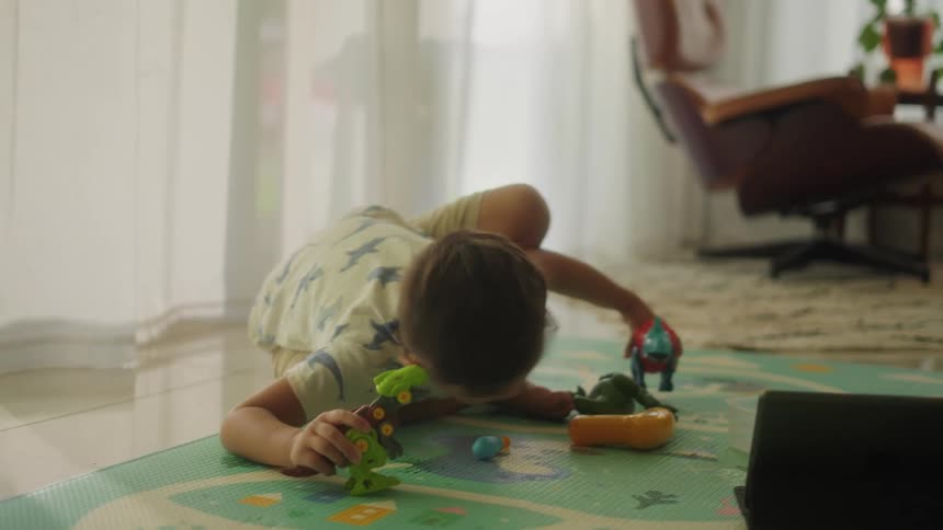 Boy play with toys on the floor in the living room