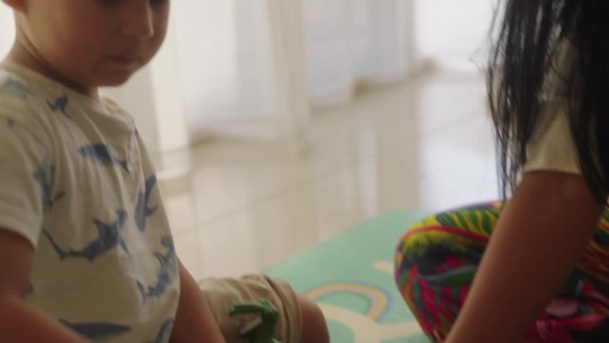 Mother and son play together on the floor with play tools