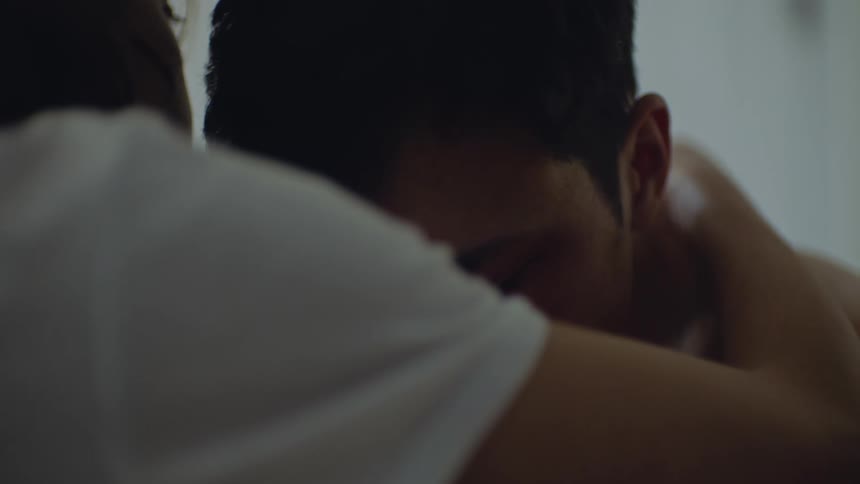Woman takes of her necklace and puts in on her partner neck