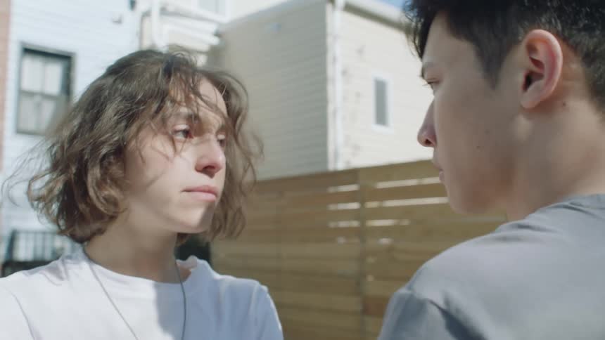 Young man stops his girlfriend from smoking on the backyard and walk back home together holding hands