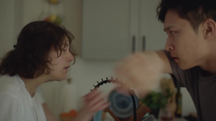 Young couple perform an interpretative dance while washing the dishes at home