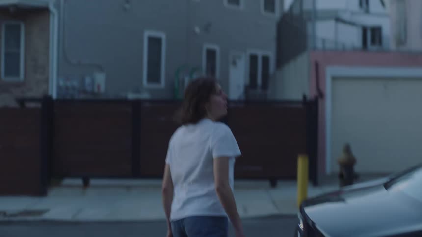 Agitated young woman exits the house desperately searching for someone in the neighborhood