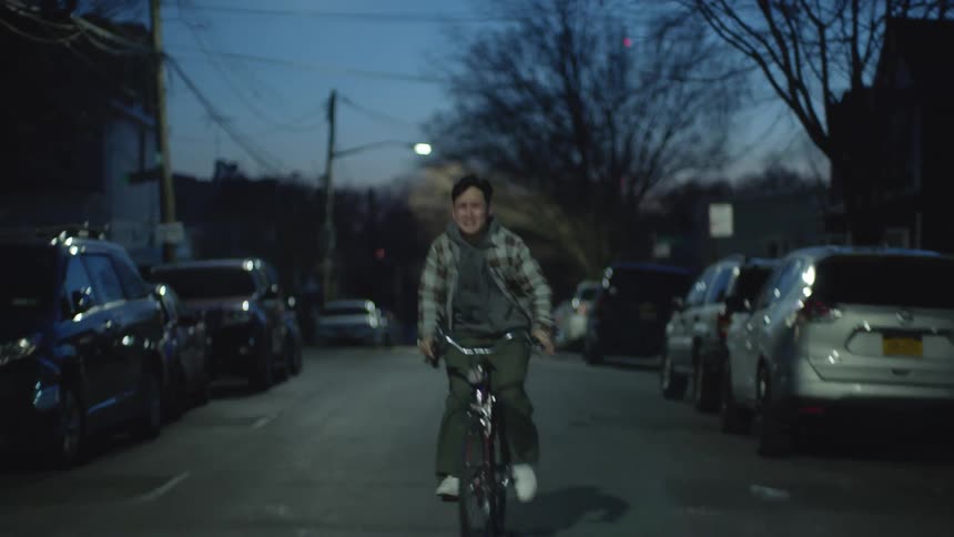 Depressed man cycles in the street crying and screaming at dusk