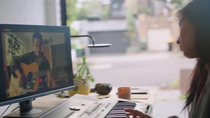 Two people play musical instruments over video call