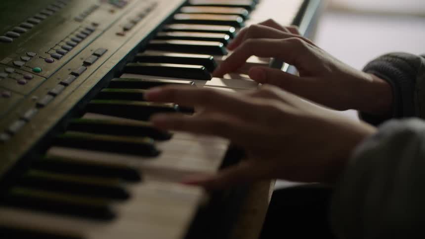 A person is playing the piano while sitting indoors