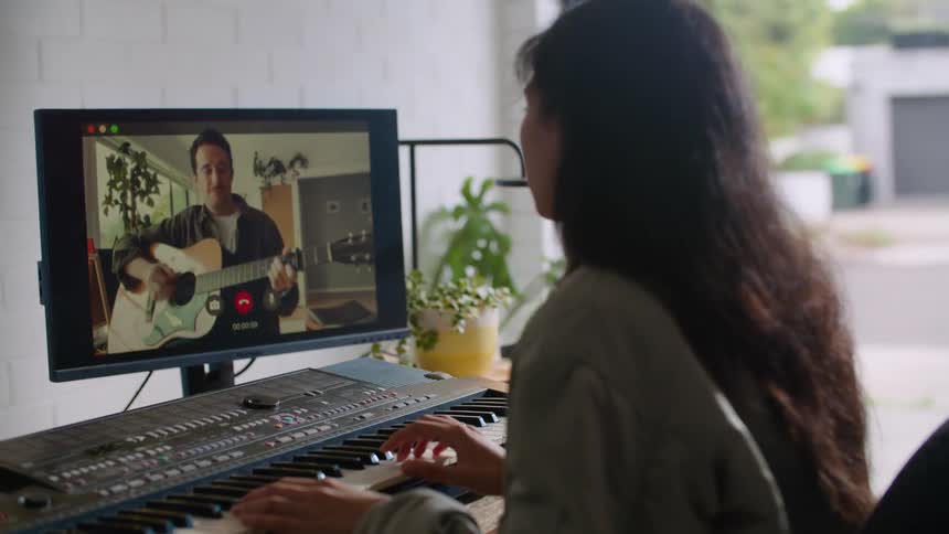 A man and woman play musical instruments over video