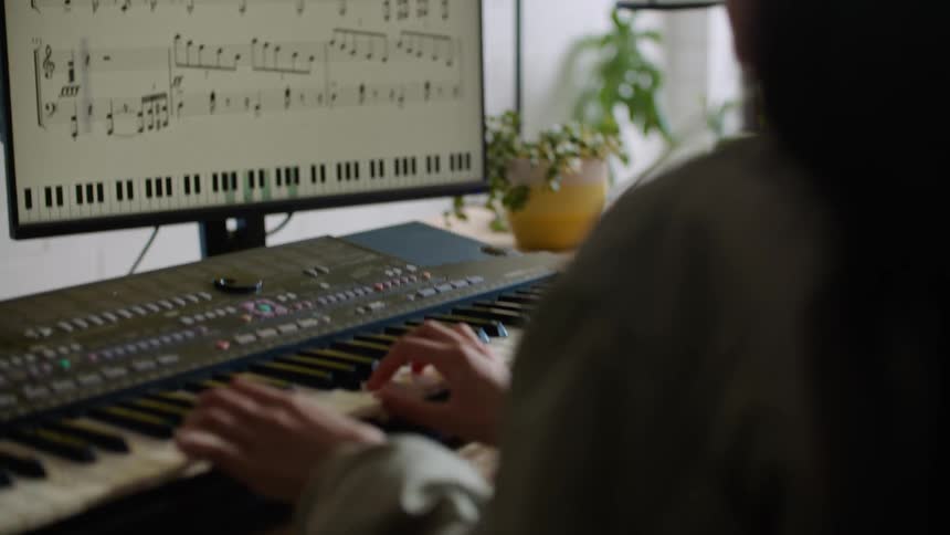 A woman is playing the keyboard instrument indoors