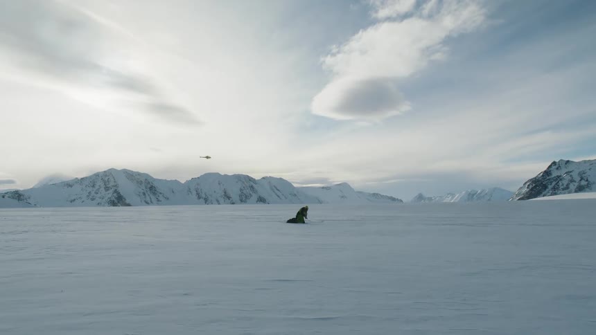 Mountaineer hikes through deep snow in the snowy field