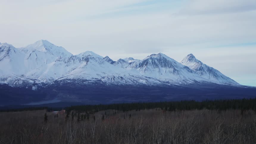 Aerial view of a mountain range during winter is displayed