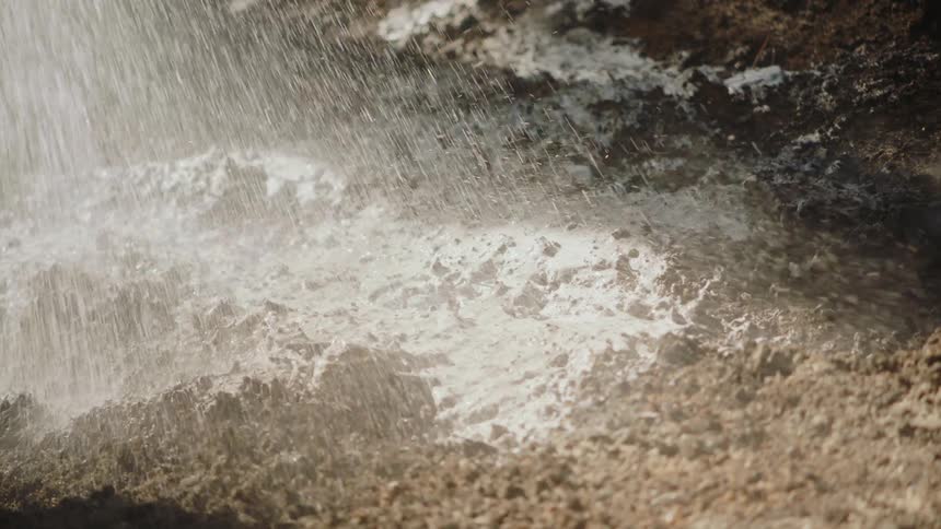 Water is sprayed on a field of dirt