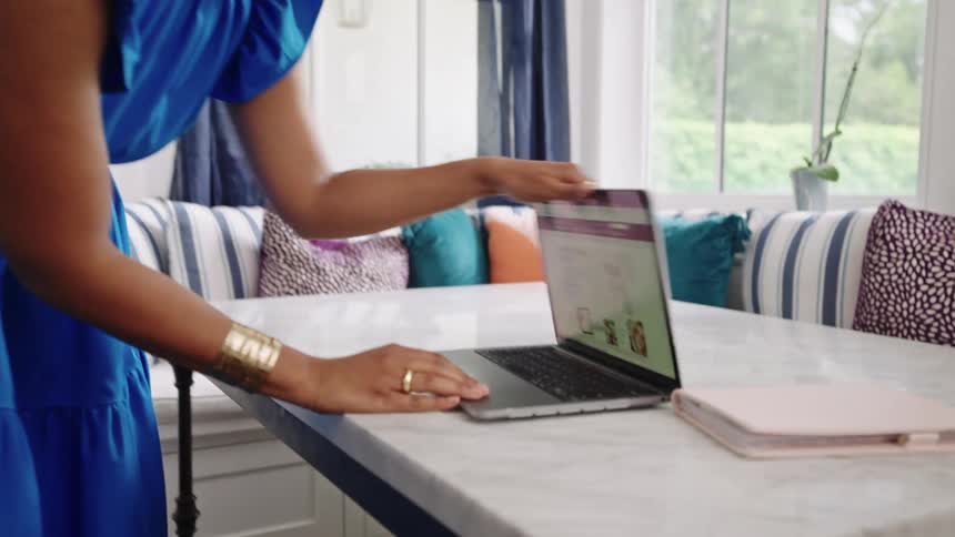 A female is moving her laptop off of a table