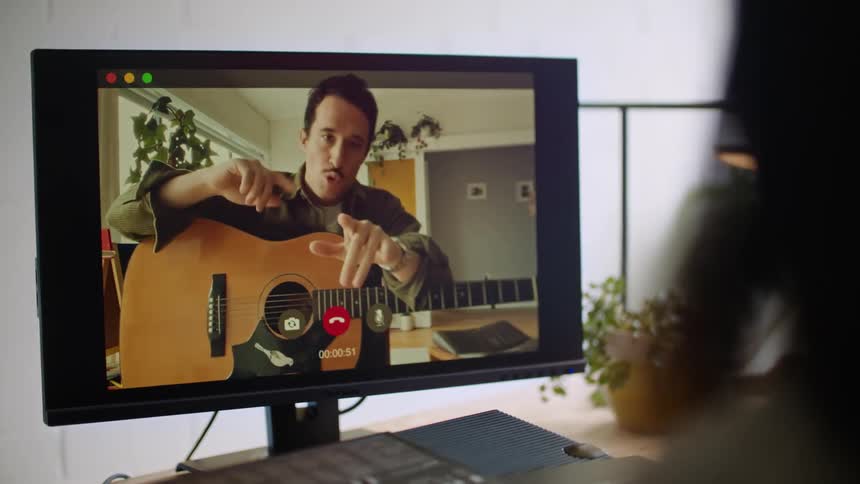A man is playing guitar on a video call