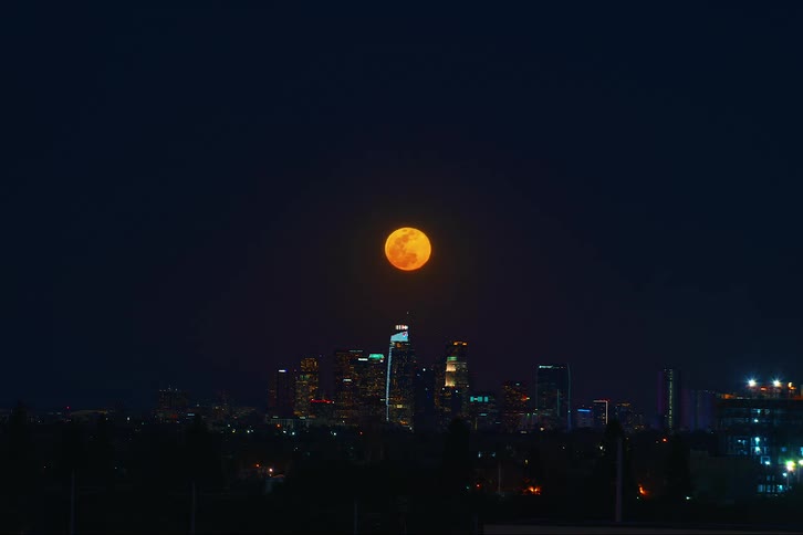 Aerial view of a downtown Los Angeles and the moon during time lapse photography
