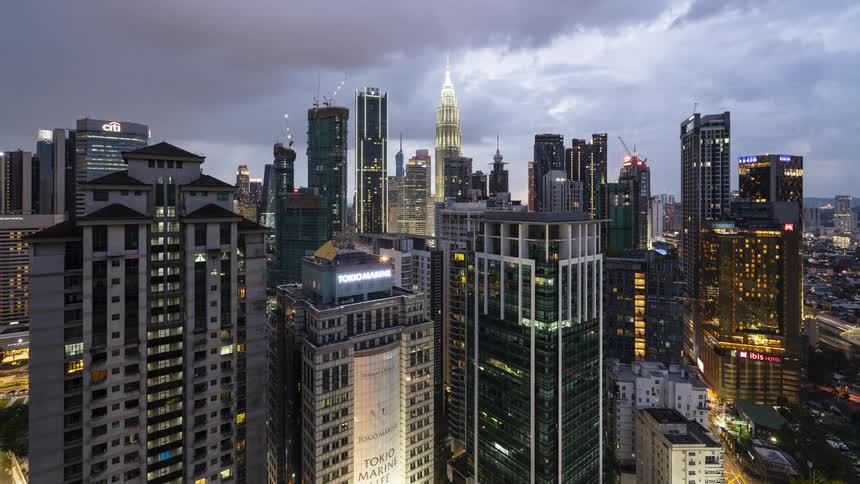 Time lapse of endless view of illuminated skyscrapers and high rise buildings in KL city at sunset