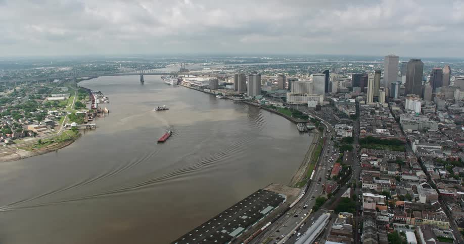 A stunning 4K aerial footage of Downtown New Orleans and the Mississippi River as seen from the French Quarter during a partly cloudy day