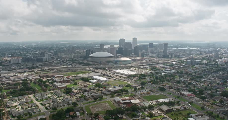 Aerial footage orbiting Downtown New Orleans skyscrapers and the Superdome during the day showcasing the central business district and surrounding neighborhoods for leisure and recreation in Louisiana