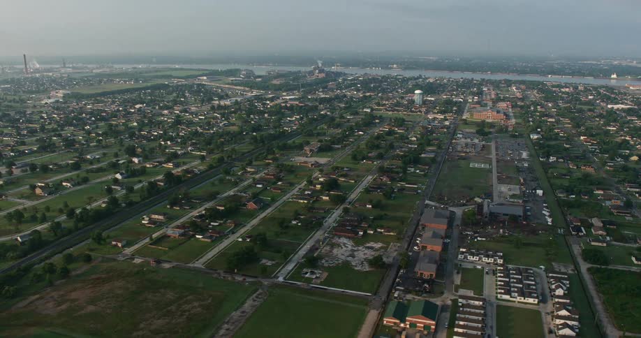 A 4K aerial view at sunrise of Lower Ninth Ward neighborhood in New Orleans Louisiana with urban residential houses and cloudy skies