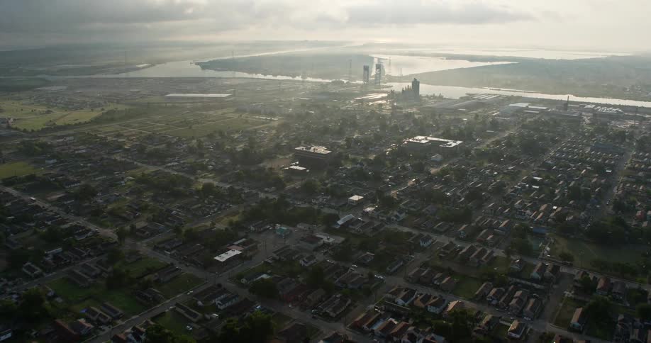 Aerial footage of a flyover above Upper Ninth Ward towards a factory by the Canal at sunrise in New Orleans Louisiana