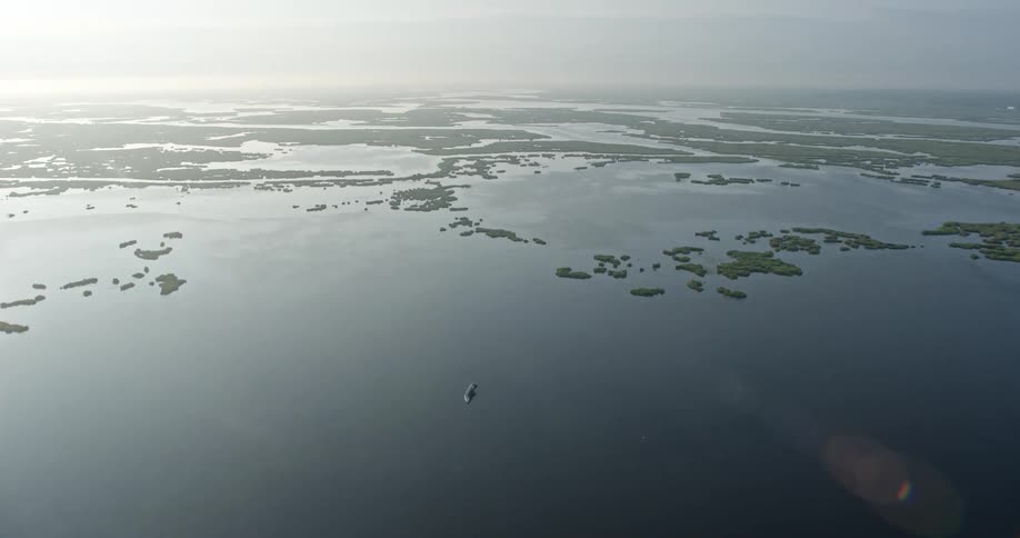 A breathtaking 4K aerial fly over captures the stunning sunrise scene of small green islands in marshland and bayou during summer in St Bernard Parish Louisiana