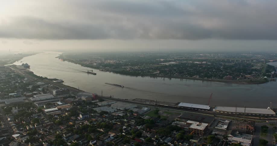 A stunning 4K aerial shot captures sunrise over the Mississippi River as barges transit through the French Quarter of New Orleans Louisiana