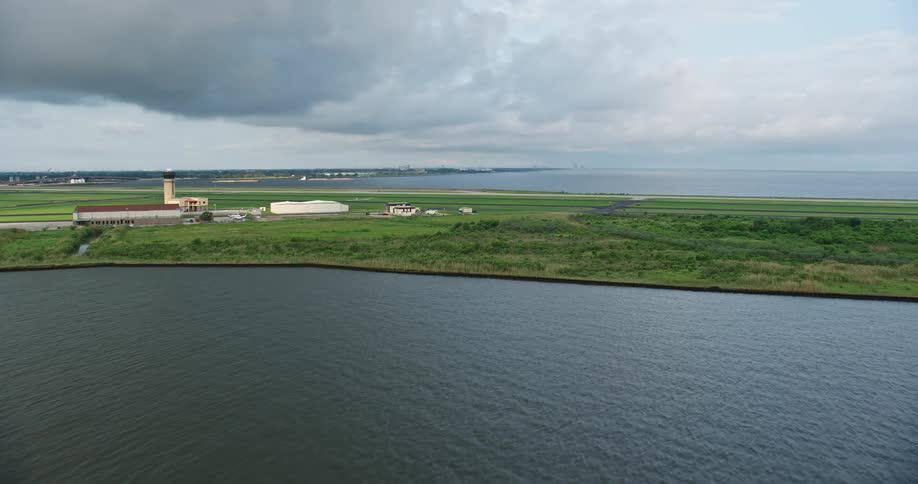 A stunning 4K aerial footage captures the sunrise approach to New Orleans Lakefront Airport amidst cloudy skies in Louisiana
