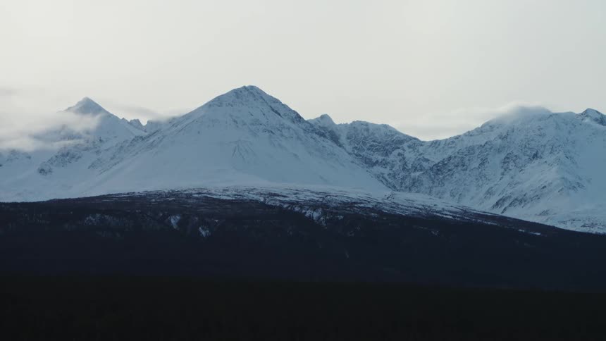 Snow covered mountains are displayed at midday