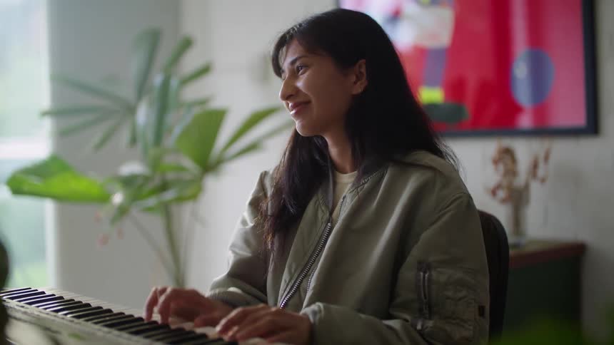 A woman playing a piano in a room