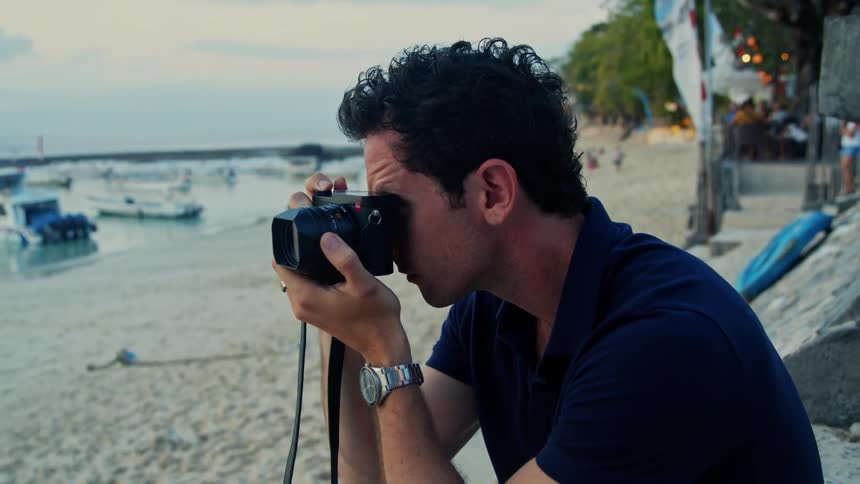 A man is taking photos on the beach