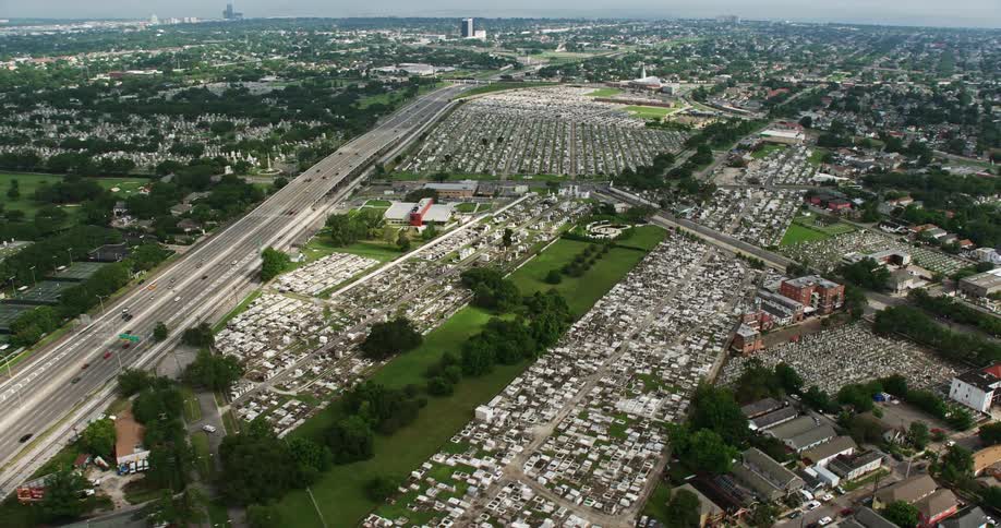 An aerial 4K footage showcasing several cemeteries in Lakeview New Orleans Louisiana on a partly cloudy day depicting the resting places like Cypress Grove Cemetery Greenwood Cemetery Charity Hospital Cemetery and St Patricks Cemetery No1