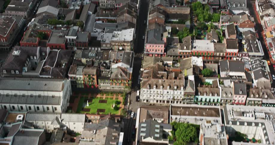 A breathtaking 4K birds eye view of French Quarter street in New Orleans reveals Downtown skyscrapers on a cloudy day